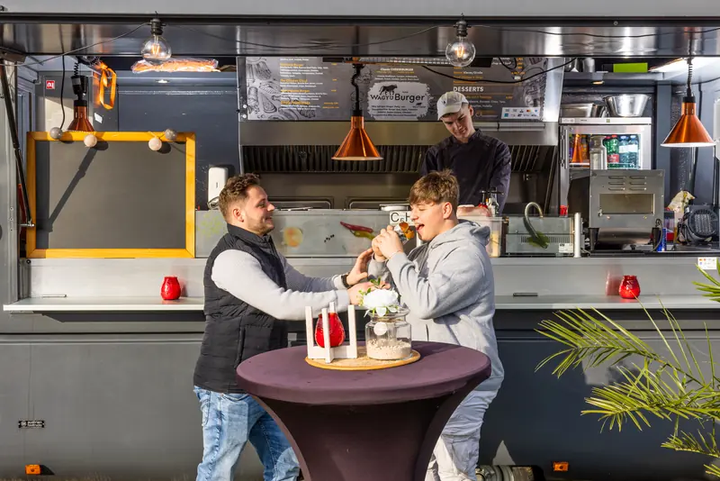 Das Team von Le Bistro Foodtruck am Truck mit Stehtisch und Burger